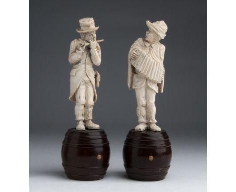 A pair of carved ivory figures of street musicians -  Germany, late 19th Century; ; on a wooden turned barrel bases. 22.5 cm,