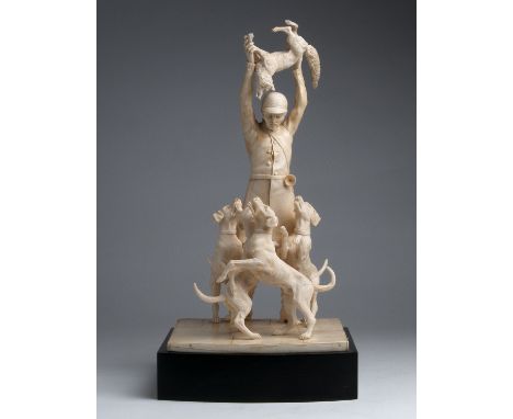 A carved ivory figural group of hunter holding a fox and his three dogs - England,  19th Century; ; on a wooden base. 47 cm, 