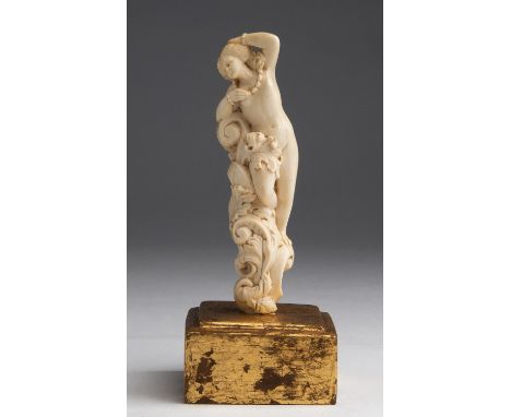 A carved ivory nude female figure - France, 19th Century; ; on a gilded wood base. 16.2 cm, 6 3/8 in high overall, weight 158