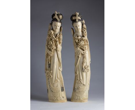 A pair of carved ivory figures of Guanyin holding peonies and wearing layered robes - China, late 19th / early 20th Century (