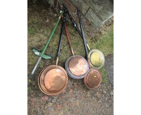 A collection of warming pans, together with a pogo stick