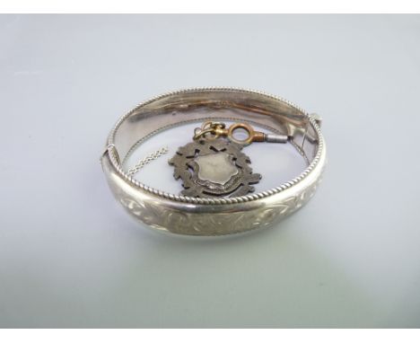 CHASED DECORATED SILVER BANGLE and an Albert watch fob, Chester 1959, 27.2grms and Birmingham 1920, 4.5grms respectively