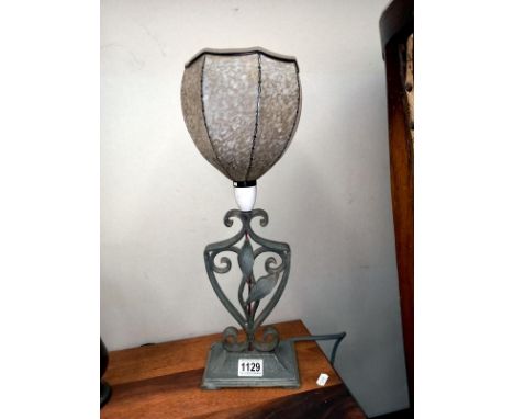A vintage wrought iron table lamp with glass shade