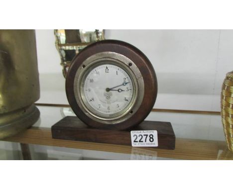 A 1920's Smiths, Cricklewood Clock Works, London car clock mounted in a wooden case.