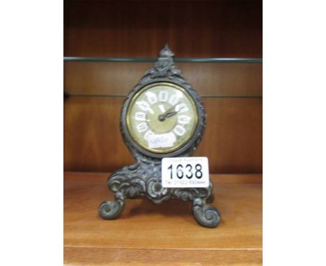 A small metal mantel clock.