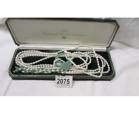 A long pearl and jade necklace.