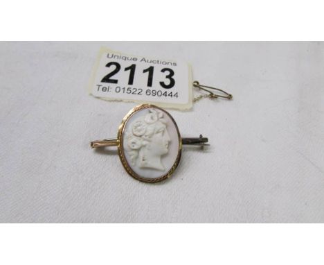 A 9ct gold cameo brooch with safety chain.
