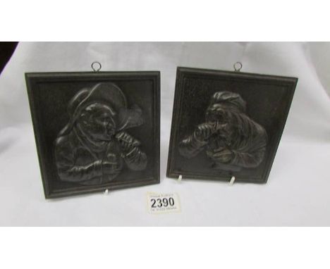Two metal portrait wall plaques.
