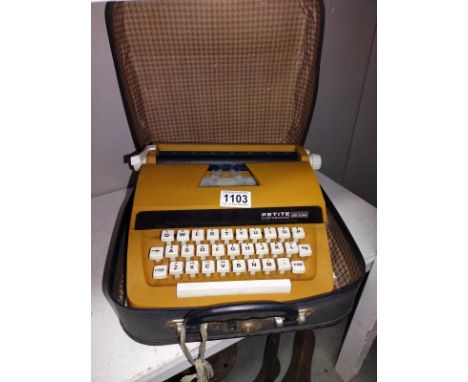 A cased vintage Petite International Delux typewriter