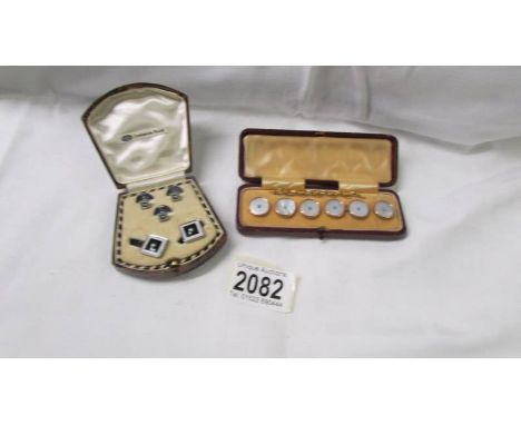 A cased set of six mother of pearl buttons and a cases set of cufflinks with matching tie pins.