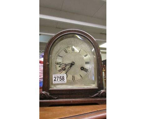 An oak 8 day mantel clock with silvered dial, in working order.