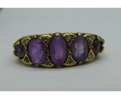 An 18ct gold, five stone amethyst ring, also set with small diamonds, one amethyst chipped, weight 5.4g, size P