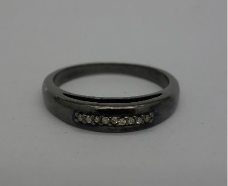 An oxidised ring set with nine diamonds, size Q