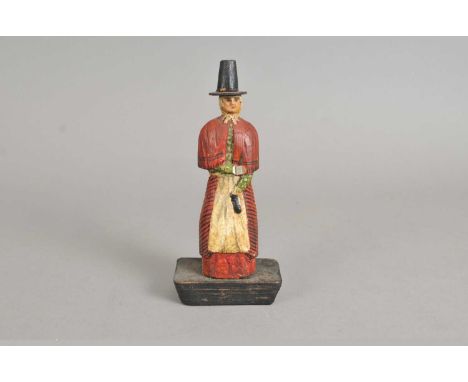 A 19th century carved wooden Welsh folk art figure, study of a lady, presented in traditional dress and stovepipe hat, raised