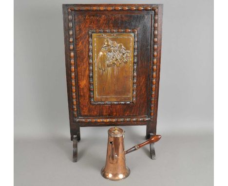 An oak framed continental fire screen, centred with a copper panel decorated with three figures playing pipes, 74 x 46 cm, to