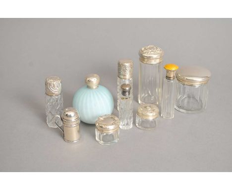 A collection of nine silver topped dressing table jars, one with yellow enamel decoration, together with a miniature silver p