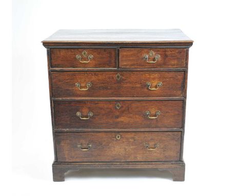 A 19 th century country oak chest of two short and three long graduated drawers, with brass loop handles and lock escutcheons