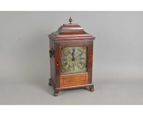 A late 19th century mahogany bracket clock, the silvered 6.5” dial with black Roman and Arabic numerals, set within cherub ma