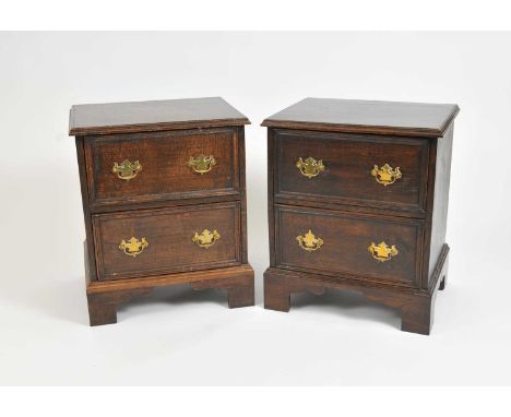 A pair of country oak bedside chests of two drawers, each fitted with brass loop handles, raised on bracket supports, 63 cm h