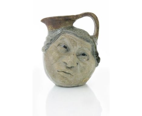 A Martin Brothers stoneware Judge face jug by Robert Wallace Martin, modelled to one side with a sideways glance, the reverse