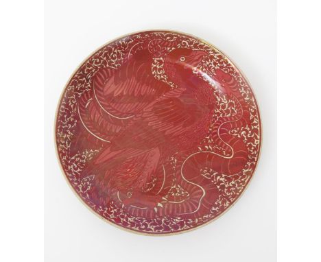 A William De Morgan pottery charger, painted to the well with a bird fighting a serpent, in ruby on a cream ground, the rever