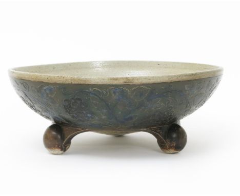 A large Martin Brothers stoneware bowl by Robert Wallace Martin,  low, flaring form on three ball feet, the bowl incised with