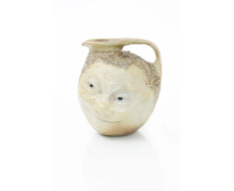 A large Martin Brothers stoneware face jug, modelled to one side with a merry smiling face, the reverse a debaunched expressi