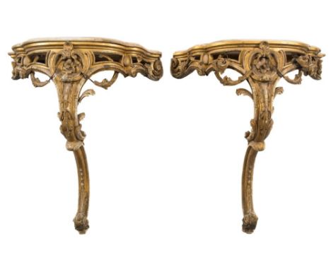 A pair of 19th Century carved giltwood and gesso console tables:, of serpentine fronted outline, each surmounted by a panel o