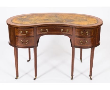 An Edwardian mahogany and inlaid kneehole desk:, of kidney-shaped outline, crossbanded in satinwood, bordered with boxwood an