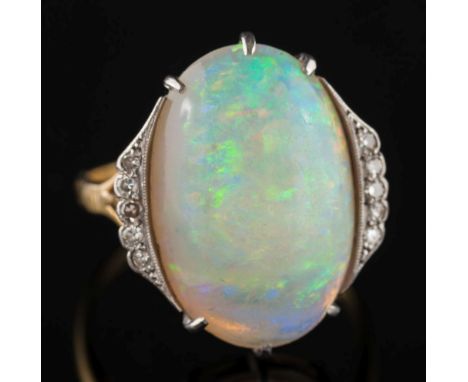 An 18ct gold, opal and diamond ring: with central oval opal 19.2mm long x 13.2mm wide, claw set between diamond five-stone sh