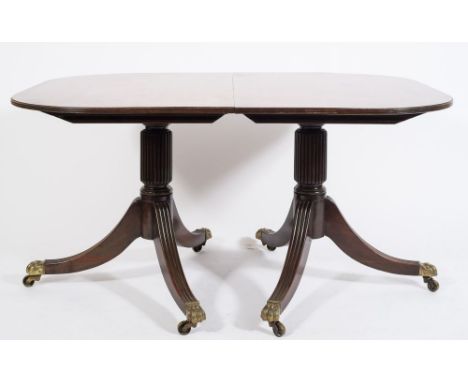 A late 19th century mahogany D-end three pillar dining table in the Regency taste:, the top with a reeded edge on turned and 