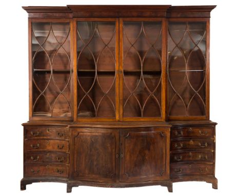 A mahogany breakfront library bookcase:, the upper part with a moulded cornice, fitted with adjustable shelves enclosed by tw