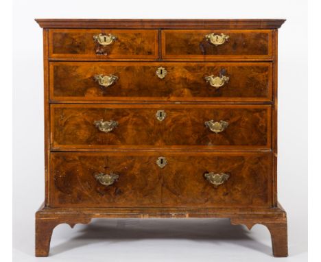 An 18th Century walnut and feather banded rectangular chest:, the quarter veneered top with a wide crossbanded border, contai