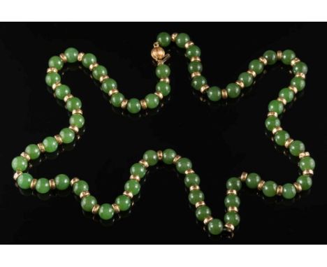 A jade bead single-string necklace: each bead approximately 8mm diameter and between hammered yellow metal beads, the clasp s