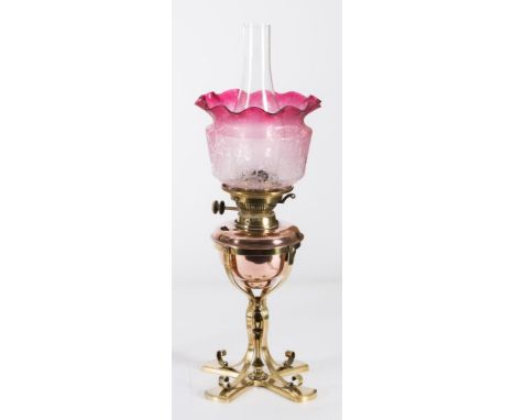 An Arts & Crafts influence brass and copper oil lamp: with Hink's No 2 Duplex wick holder, copper cylindrical reservoir on a 