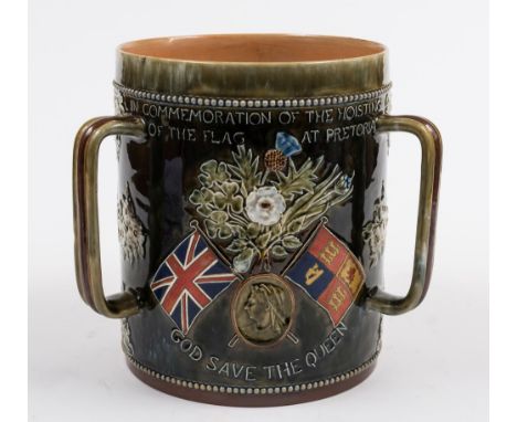 A large Doulton Lambeth stoneware Boer War commemorative three-handled loving cup or tyg: inscribed 'In Commemoration of the 