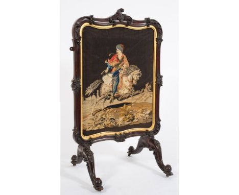 A Victorian carved mahogany cartouche-shaped firescreen:, with inset needlework panel depicting a Near Eastern figure on hors