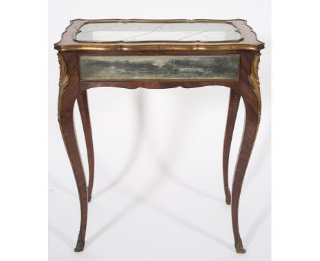 A 19th Century French kingwood, brass and gilt metal mounted bijouterie display table:, of serpentine outline, the hinged gla