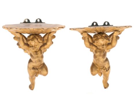 A pair of carved giltwood wall brackets: in the Florentine taste, the scalloped shaped shelf supported by a cherub bracket, 2