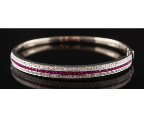A ruby and diamond mounted hinged bangle: with central row of calibre-cut rubies estimated to weigh a total of 1.5cts, channe