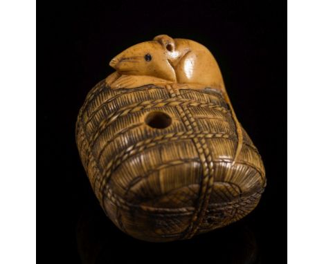 A Japanese carved ivory netsuke of a rat seated on a rope bound bale: with an articulated serpent's head  emerging from a hol