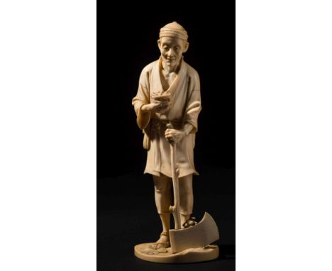 A Japanese carved ivory okimono of a sullen peasant : holding a bird's nest in one hand and an axe in the other, signed to a 