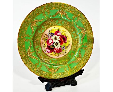 A Royal Worcester porcelain cabinet plate, with profusely gilded borders encircling a floral composition, signed ‘E Philips’,