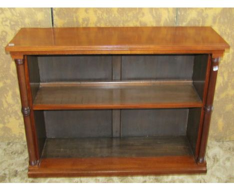 A dwarf floor standing open mahogany bookcase with turned columns flanking a fixed shelf, 80cm high x 107cm x 34cm