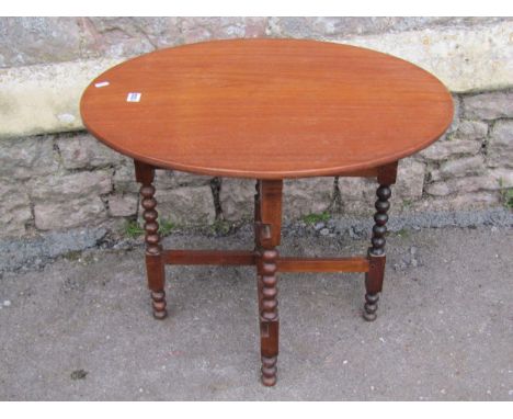 Mahogany folding coaching type table on turned bobbin supports, with applied paper registration verso