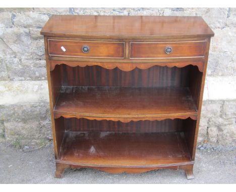 A reproduction mahogany bowfronted side cabinet with two frieze drawers over open shelves on bracket supports, 89cm high x 84