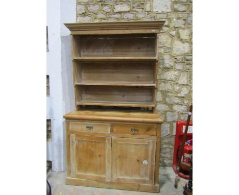 A stripped pine kitchen dresser the lower section enclosed by  two drawers and bi-fold cupboard door, the upper section with 