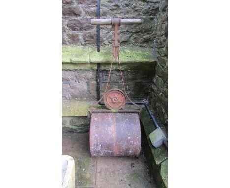 A small vintage cast iron garden roller together with a pair of painted cast iron garden bench ends with pierced scrolled det