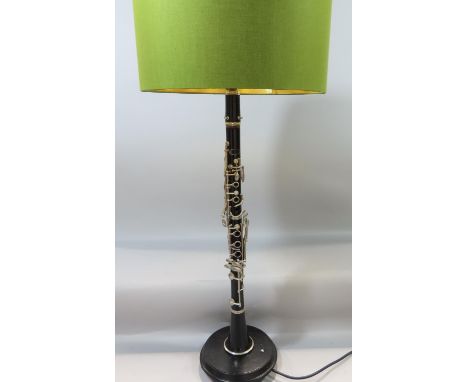 A novelty 'Clarinet' table lamp with a shade raised on a circular plinth 