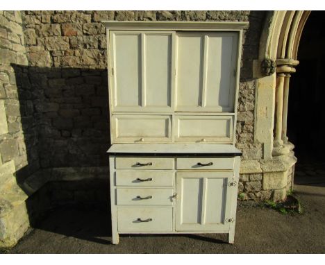A vintage painted kitchen cabinet enclosed by and arrangement of cupboards and drawers with enamel sliding work surface, 187c